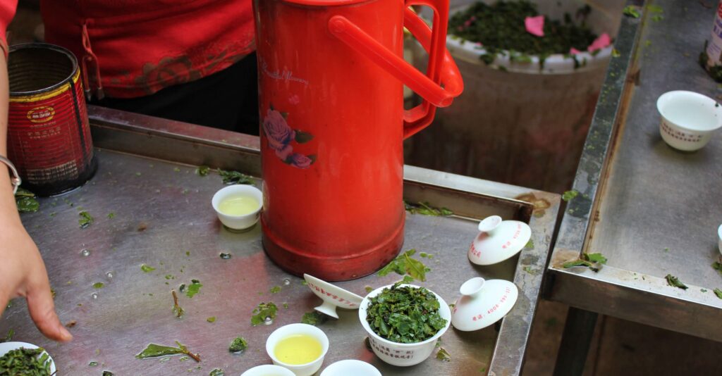red flask and gaiwans with tea brewing