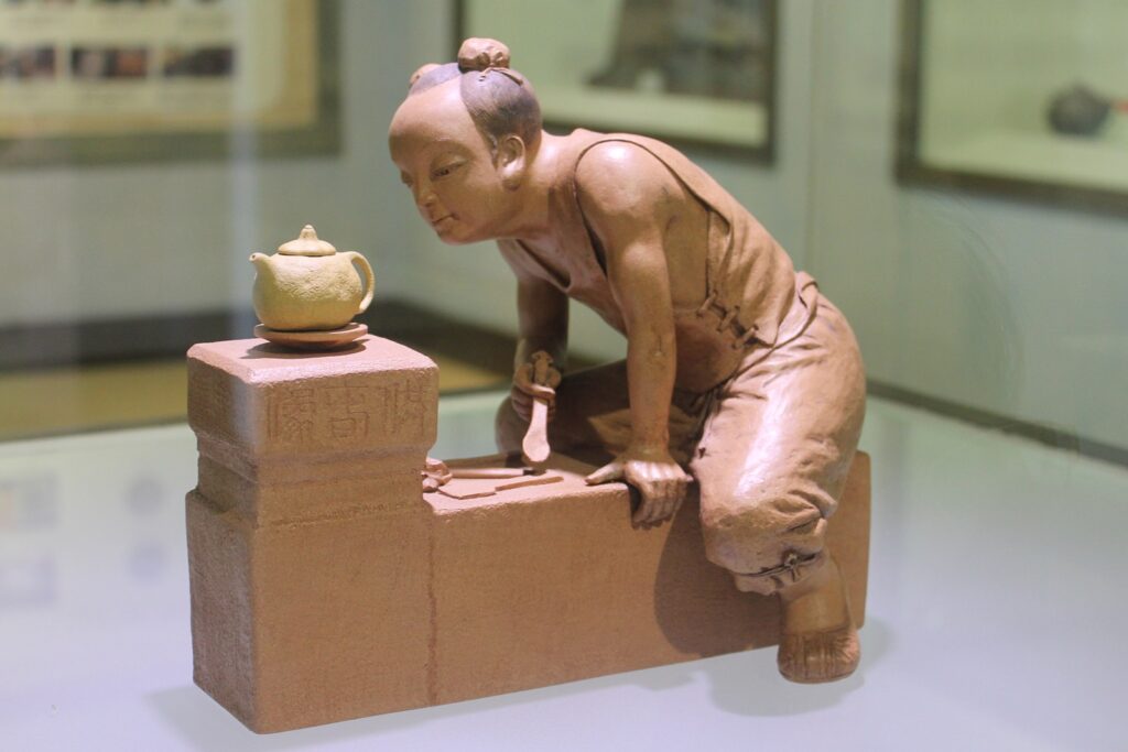 statuette of master potter admiring his teapot