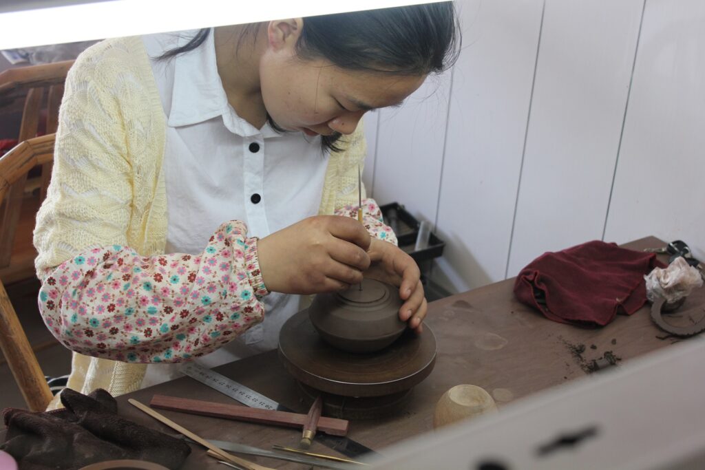 woman (master potter) making yixing teapot