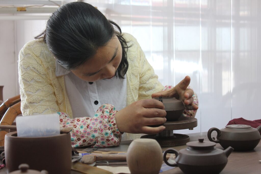 woman (master potter) making yixing teapot