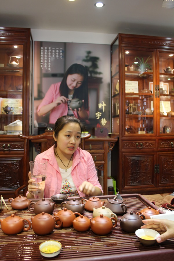 teashop owner with teapots on table