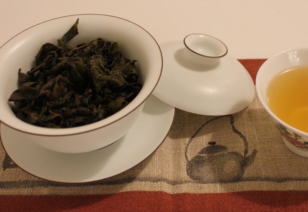 tea leaves in a gaiwan and a cup of tea