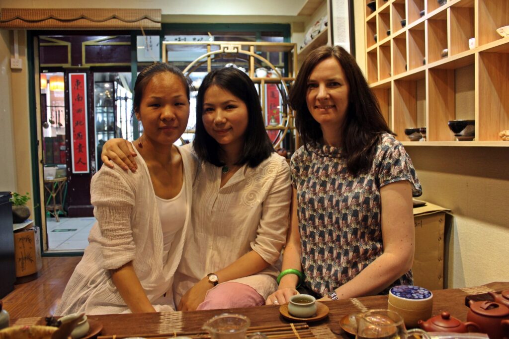 jasmine, jenni and carole 3 women sat in a tea shop, looking to camera