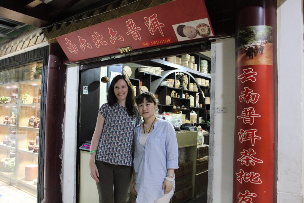 2 people standing at the entrance of a tea shop
