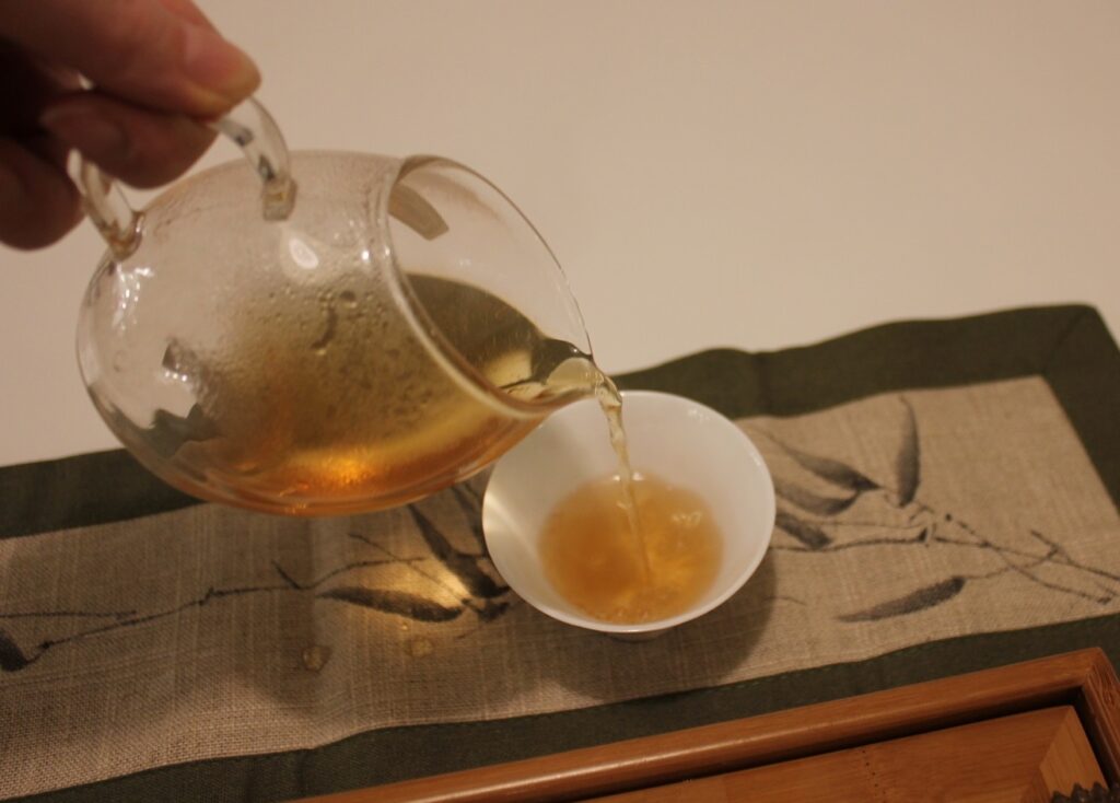 dong ding oolong liquor pouring tea from glass jug to tea cup