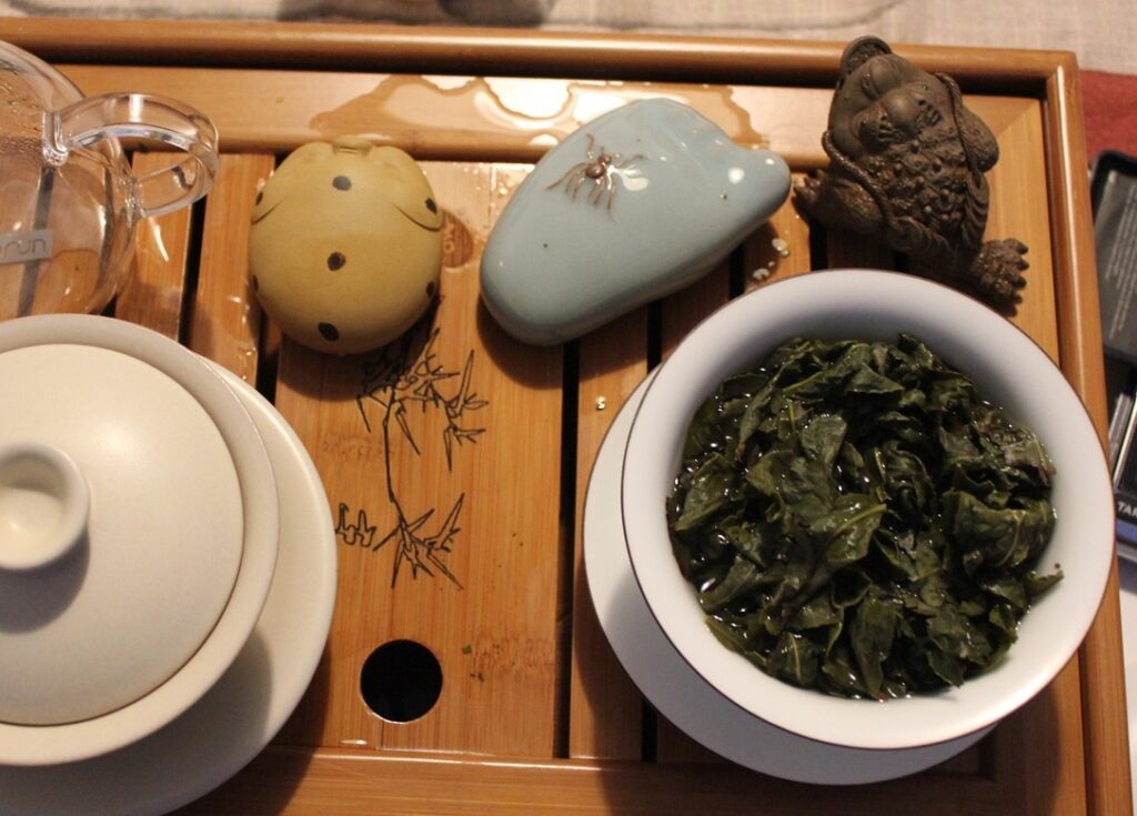 tie guan yin brewing in gaiwan tea brewing in gaiwan on a wooden tea tray