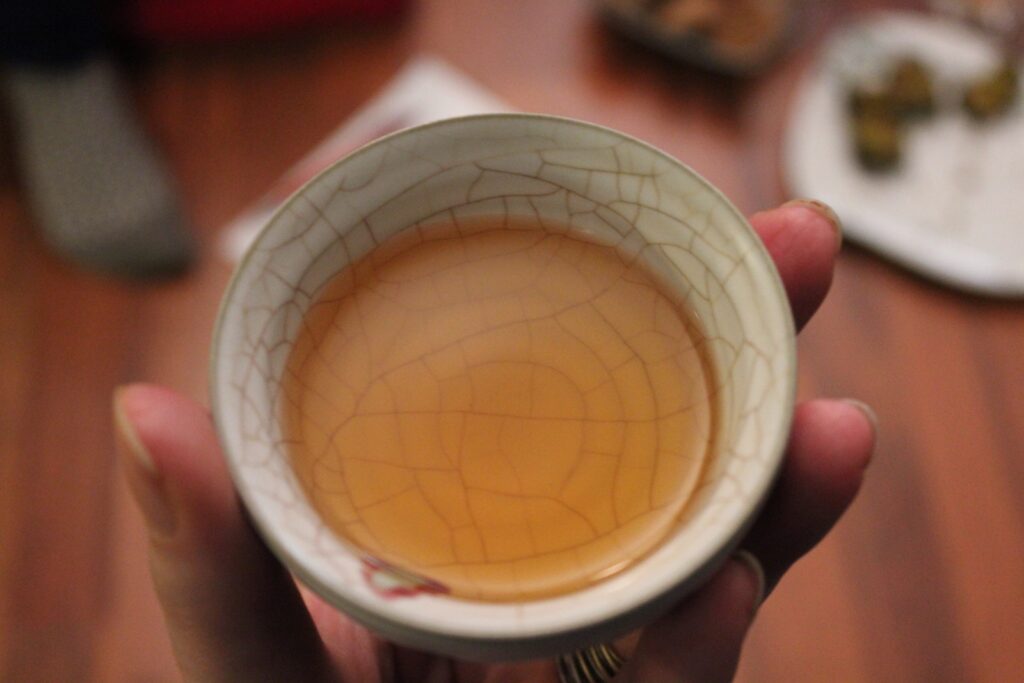 Yuan Big Green Tree tea in a tea cup being held by a hand