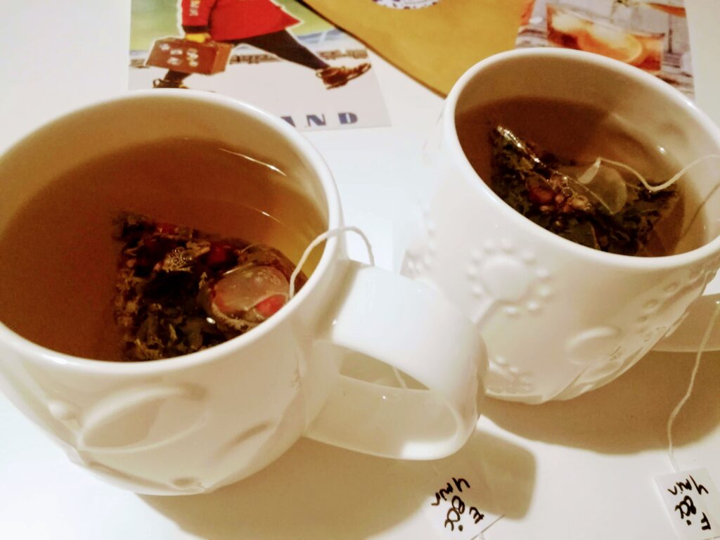 cof 2 white tea cups with tea bags brewing