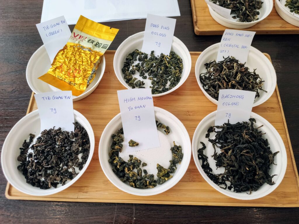 Taiwan Oolongs 6group Dry set of 6 dry tea leaves, each on a white plate, set on a wooden tray