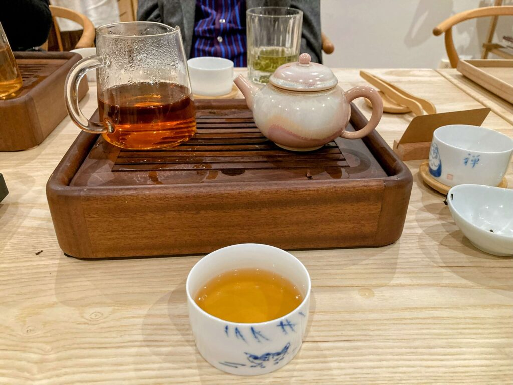 high horse black tea liquor in cup, wooden tea tray behind