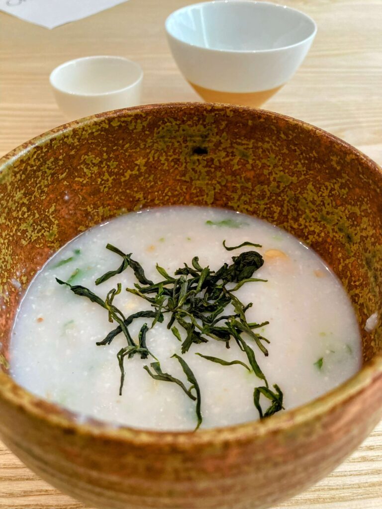 leicha-porridge close up of leicha porridge with tea leaves on top in ceramic bowl